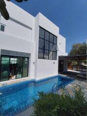Modern white two-story house with a swimming pool and large windows