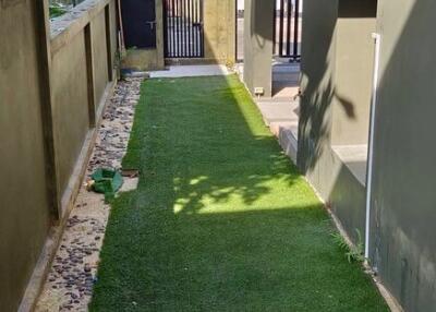 Well-maintained artificial turf path leading to a modern home entrance