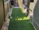 Well-maintained artificial turf path leading to a modern home entrance