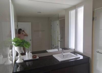 Modern bathroom with dual sinks and glass shower stall