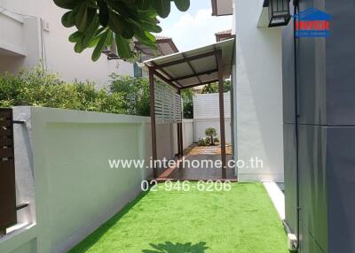 Landscaped outdoor area with artificial turf and shaded seating