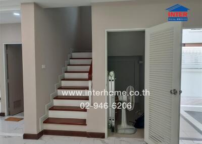 Interior view of a modern home showcasing staircase and entry to another room