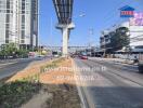 Busy urban road with traffic under an overpass, adjacent real estate advertising