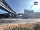 Busy urban street scene with overhead train tracks and commercial buildings