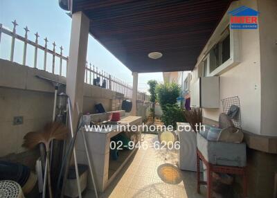 Spacious covered patio area with utility zone in a residential house