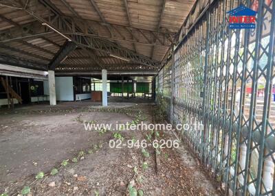 Abandoned industrial building interior with overgrown vegetation