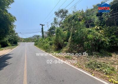 Paved road with lush greenery on the side under a clear blue sky