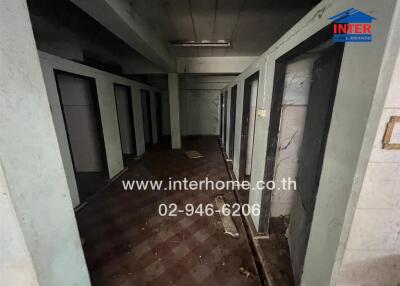 Abandoned building corridor with closed doors and debris