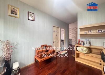 Spacious and neatly decorated living room with wooden furniture and striped wallpaper