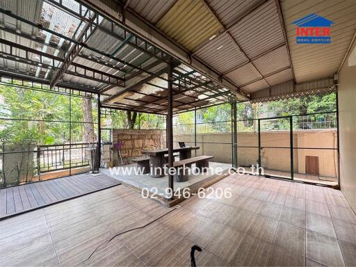 Spacious covered patio with wooden flooring and ample natural light