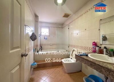 Spacious bathroom with bathtub and tiled flooring