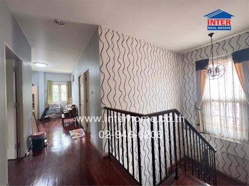 Bright and stylish hallway interior with decorative wallpaper and elegant lighting fixture