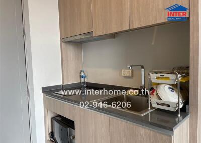 Compact modern kitchenette with built-in cabinets and appliances