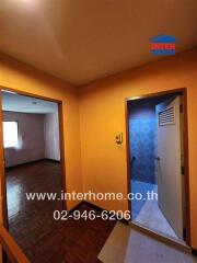 Brightly lit hallway in residential home leading to the living room and entrance