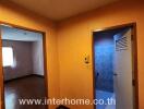 Brightly lit hallway in residential home leading to the living room and entrance