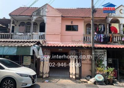 Exterior view of a two-story residential building with pink facade