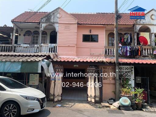 Exterior view of a two-story residential building with pink facade