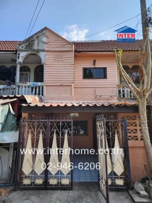 Pink two-story townhouse with gated entrance