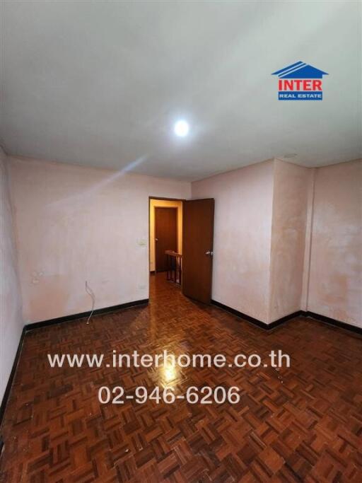 Empty bedroom with parquet flooring and light pink walls