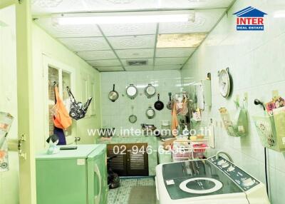 Well-equipped compact laundry room with multiple appliances and storage solutions