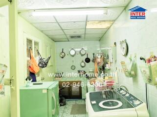 Well-equipped compact laundry room with multiple appliances and storage solutions