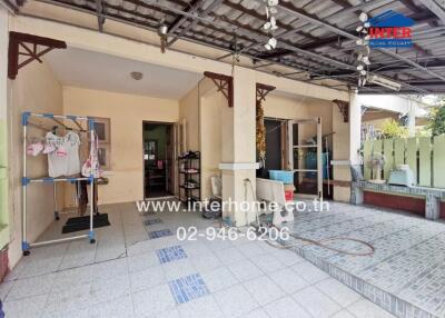 Spacious covered outdoor area with tiled flooring and storage shelves