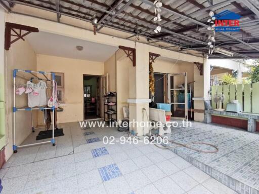 Spacious covered outdoor area with tiled flooring and storage shelves