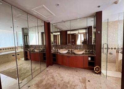Spacious bathroom with twin vessel sinks, large mirrors, and beige marble finishes