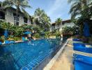 Tropical resort style pool area with blue loungers and lush greenery