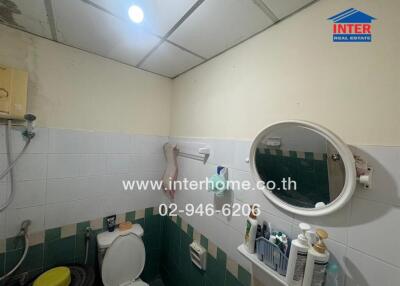 Compact bathroom with essential amenities and tiled walls
