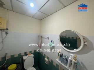 Compact bathroom with essential amenities and tiled walls