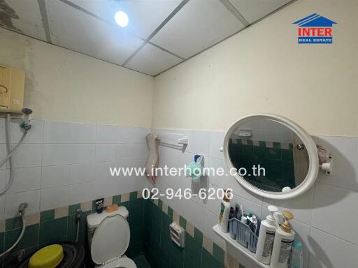 Compact bathroom with essential amenities and tiled walls