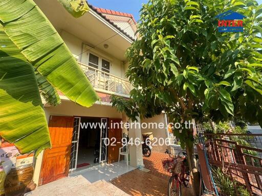 Front view of a residential house with lush greenery