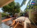 Spacious outdoor patio with lush greenery and seating area in a residential property