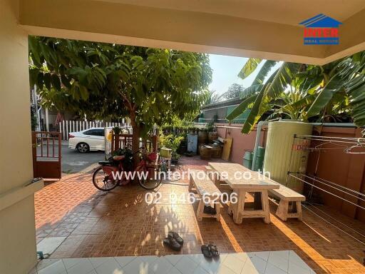 Spacious covered outdoor area with greenery and seating