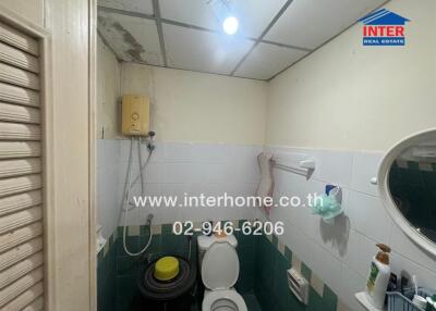 Compact bathroom with basic amenities and tiled walls