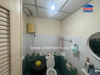 Compact bathroom with basic amenities and tiled walls