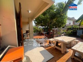 Spacious patio area with seating and abundant greenery