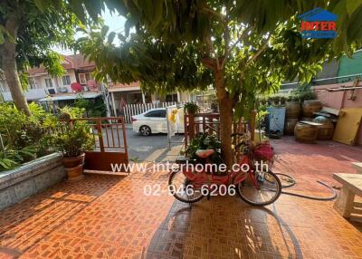 Spacious and welcoming front yard with lush greenery and tiled flooring