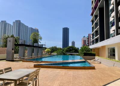 Luxurious outdoor swimming pool area with modern high-rise buildings in the background