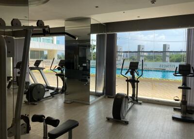Modern gym overlooking a pool with natural light