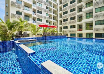 Modern residential building with a large outdoor swimming pool and seating area