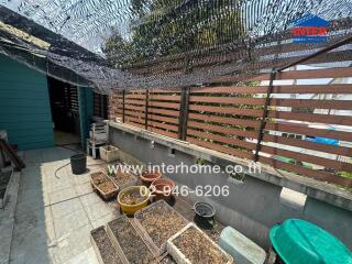 Small balcony with wooden fencing and plant containers