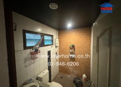 Compact bathroom with shower and tiled walls