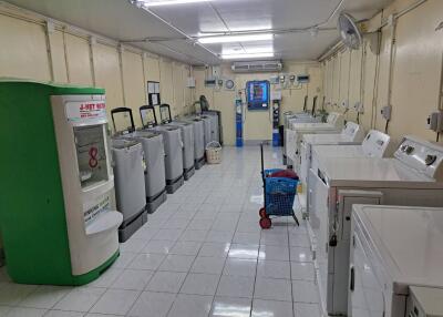 Spacious communal laundry room with multiple washing machines and storage cabinets