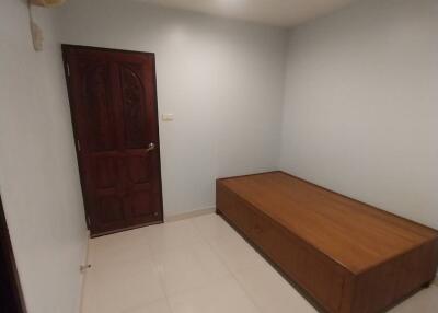Minimalist bedroom with single bed and wooden door