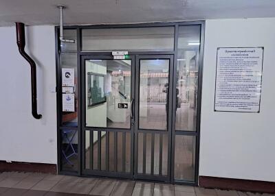 Glass door entrance of a commercial building with security and informational signage