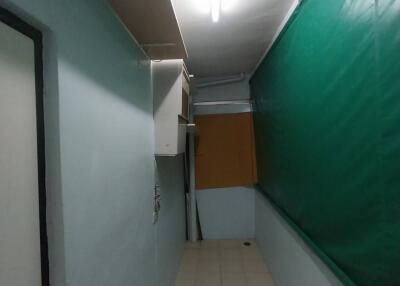 Narrow hallway in a building with green and white walls