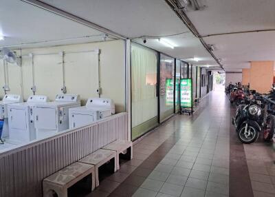Interior view of a building with a laundry area and a motorcycle parking