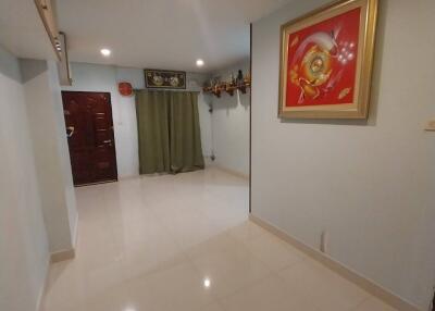 Bright and spacious hallway with glossy tiled floor and artistic wall decor